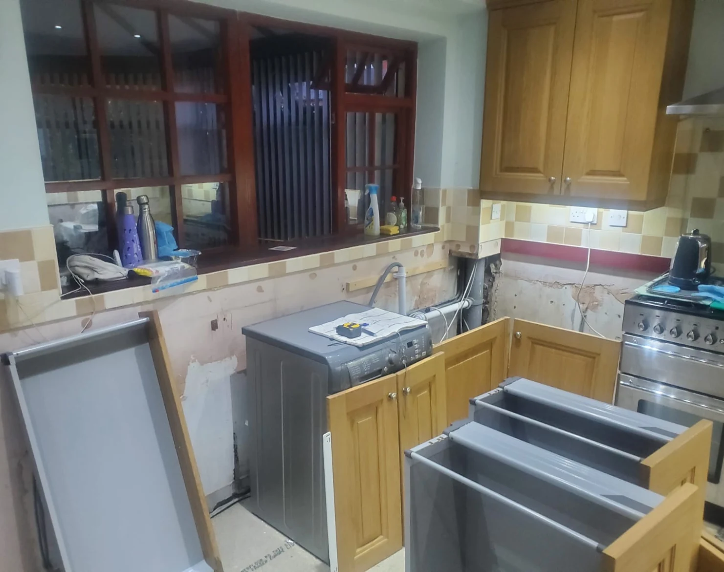 Sheila's kitchen before — stripped back after insurance damage